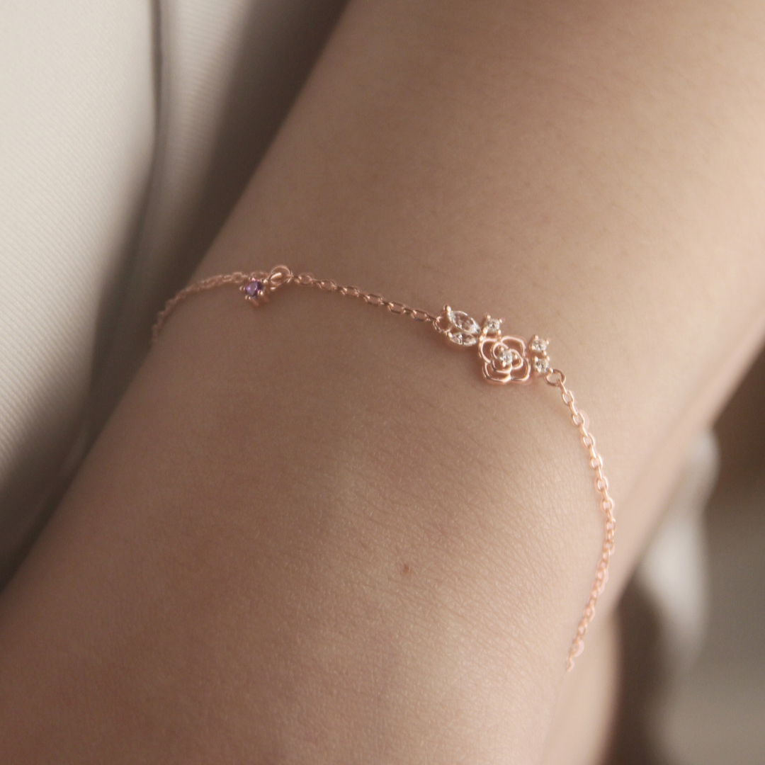 Rose gold Suga inspired Amygdala bracelet with lotus design on a person's wrist against a neutral background.