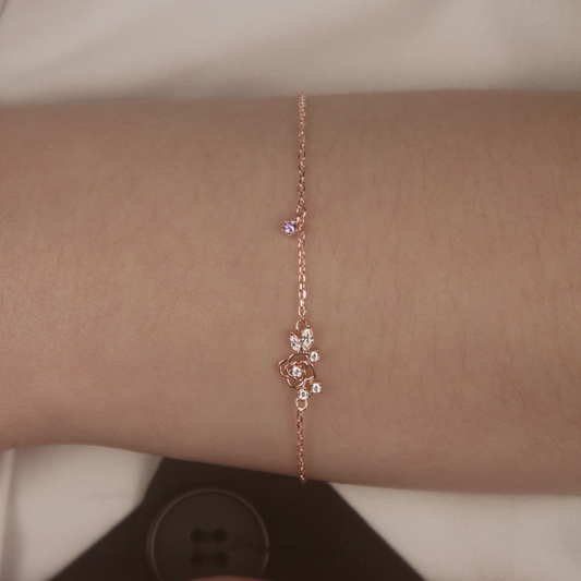 Rose gold Suga inspired Amygdala bracelet with lotus design on a person's wrist against a neutral background. 