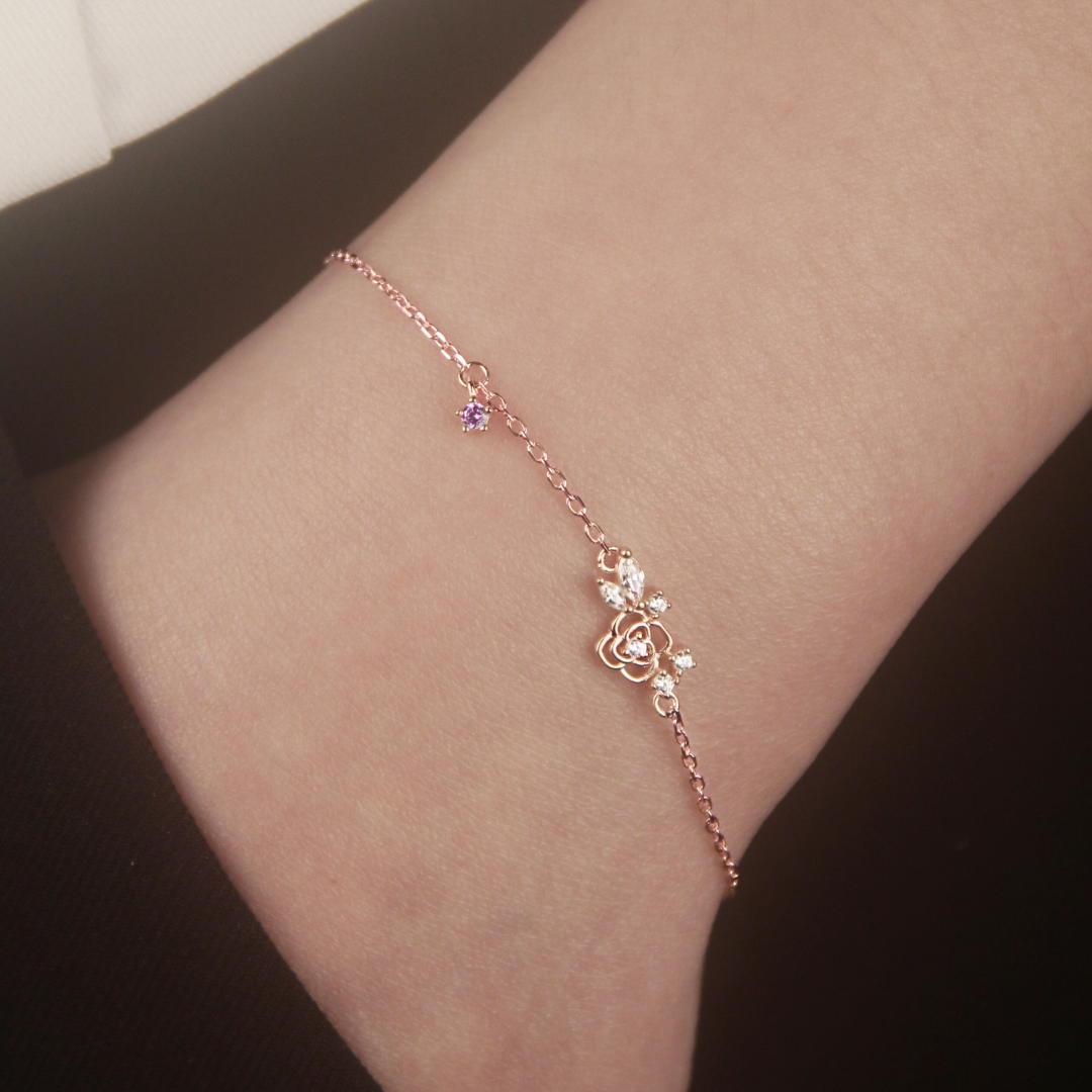 Rose gold Suga inspired Amygdala bracelet with lotus design on a person's hand against a neutral background. 